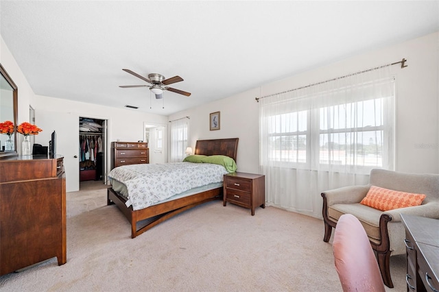 carpeted bedroom featuring a spacious closet, ceiling fan, and a closet