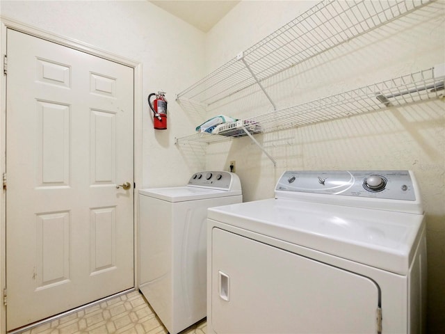 washroom with washer and clothes dryer and light tile patterned floors