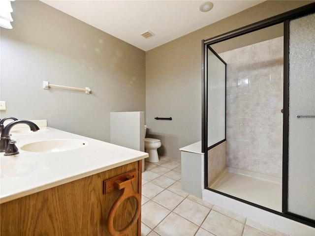 bathroom featuring vanity, walk in shower, tile patterned flooring, and toilet