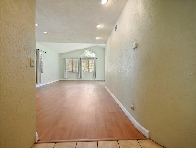 interior space with light hardwood / wood-style flooring and vaulted ceiling