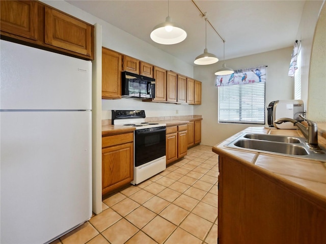 kitchen featuring decorative light fixtures, light tile patterned flooring, white appliances, sink, and track lighting