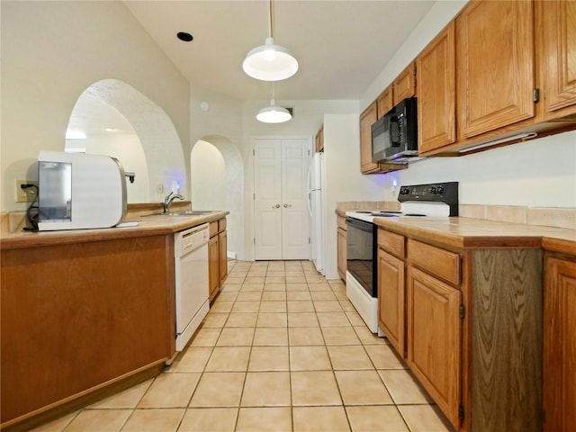 kitchen with pendant lighting, white appliances, sink, tile countertops, and light tile patterned floors