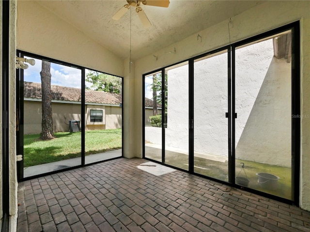 unfurnished sunroom featuring ceiling fan