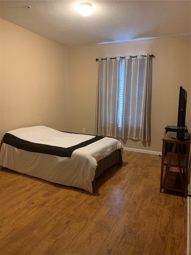 bedroom featuring a textured ceiling and hardwood / wood-style floors