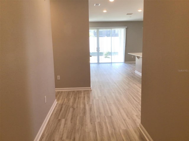 corridor with light hardwood / wood-style floors