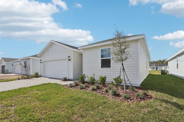 single story home featuring board and batten siding, a front yard, decorative driveway, and an attached garage