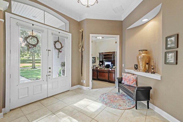 tiled entryway with french doors and crown molding