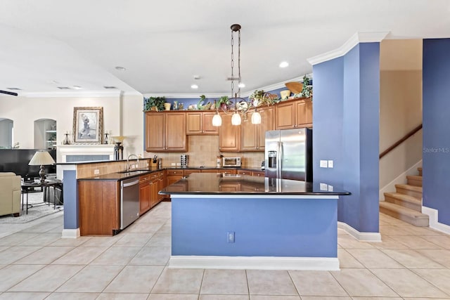 kitchen with kitchen peninsula, pendant lighting, stainless steel appliances, light tile patterned floors, and sink