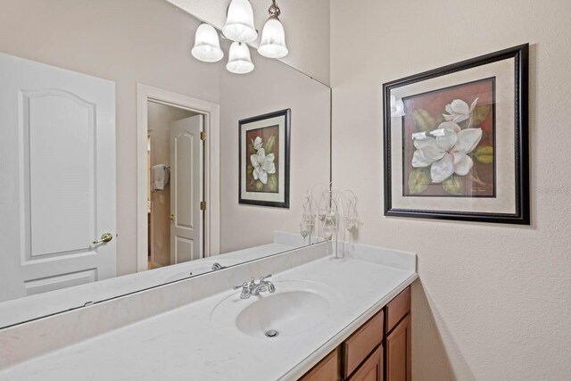 bathroom with a chandelier and vanity