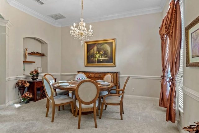 dining room featuring crown molding, light carpet, and a chandelier