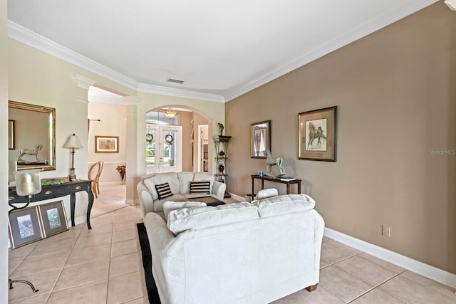 tiled living room featuring french doors, crown molding, and decorative columns