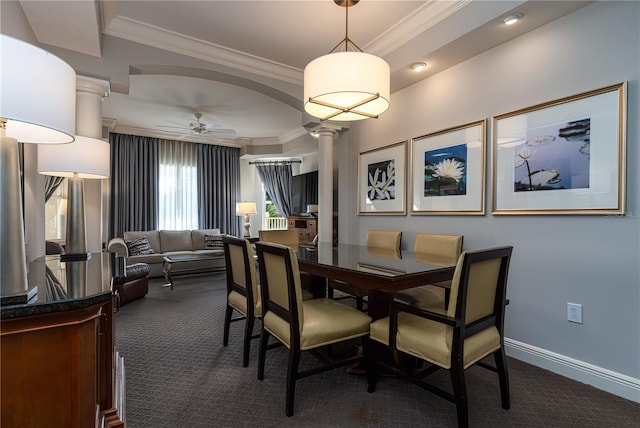 dining area featuring crown molding, ornate columns, ceiling fan, and dark colored carpet