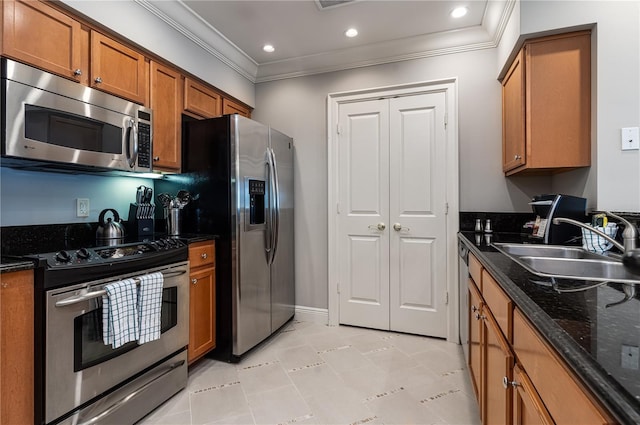 kitchen with dark stone countertops, sink, crown molding, and stainless steel appliances