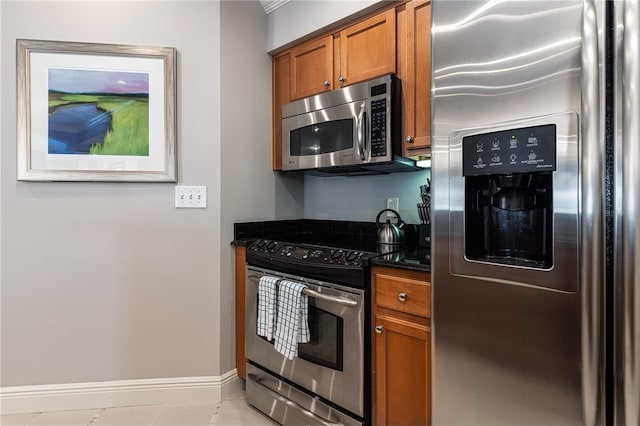 kitchen featuring dark stone counters and appliances with stainless steel finishes