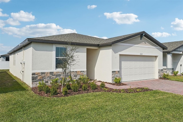 ranch-style house with decorative driveway, stone siding, roof with shingles, a front yard, and an attached garage