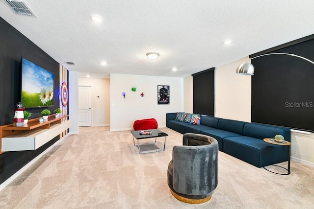 carpeted living room featuring a textured ceiling