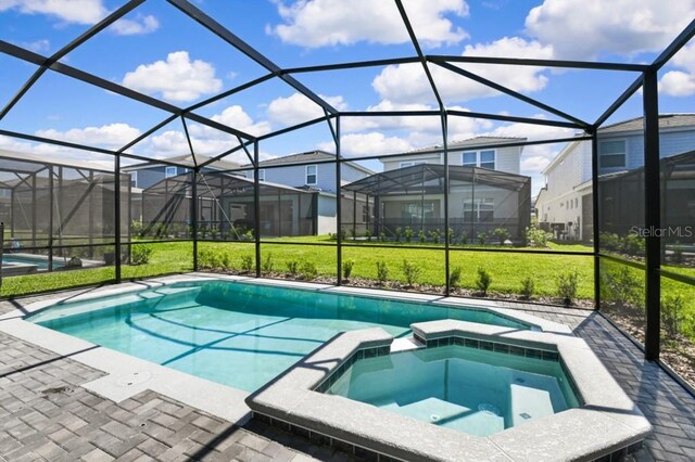 view of pool with an in ground hot tub, a patio, a yard, and a lanai