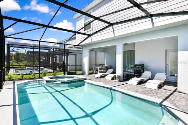 view of swimming pool featuring an in ground hot tub, a patio area, and a lanai