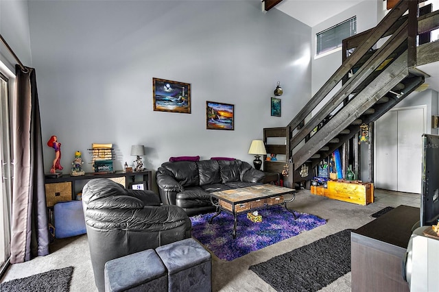 carpeted living room featuring beam ceiling and high vaulted ceiling