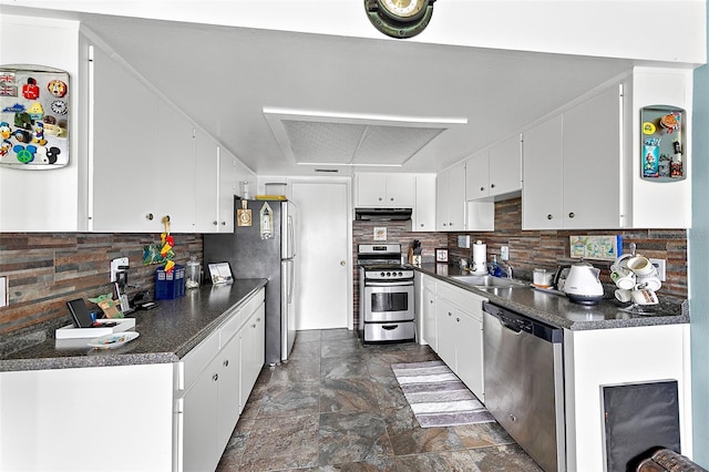 kitchen with stainless steel appliances, sink, white cabinets, and backsplash