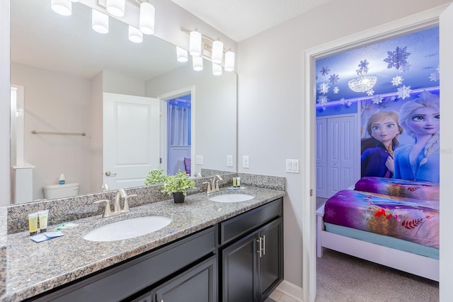 bathroom featuring toilet and dual bowl vanity