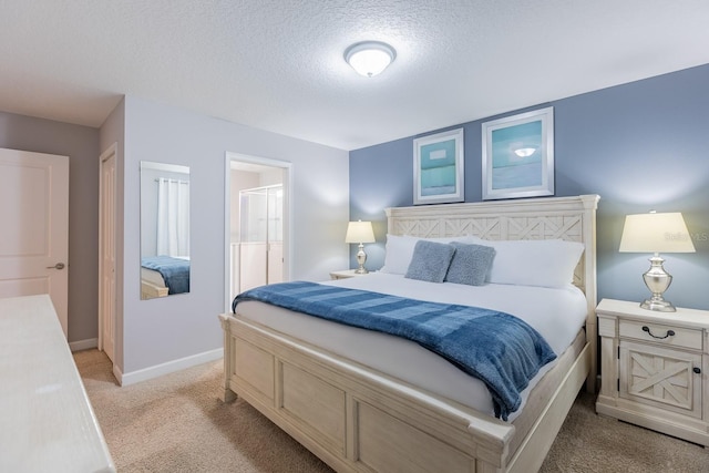 carpeted bedroom with a textured ceiling and connected bathroom