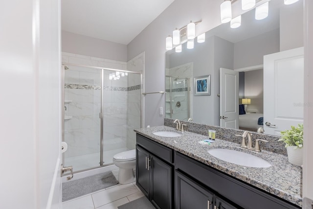 bathroom featuring a shower with shower door, tile patterned floors, double sink vanity, and toilet