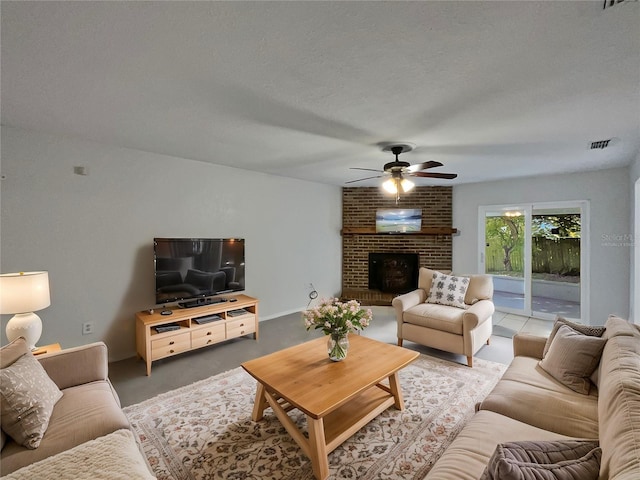 living room with ceiling fan, a textured ceiling, and a brick fireplace