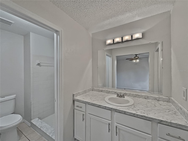 bathroom featuring tile patterned floors, a textured ceiling, ceiling fan, a shower, and toilet