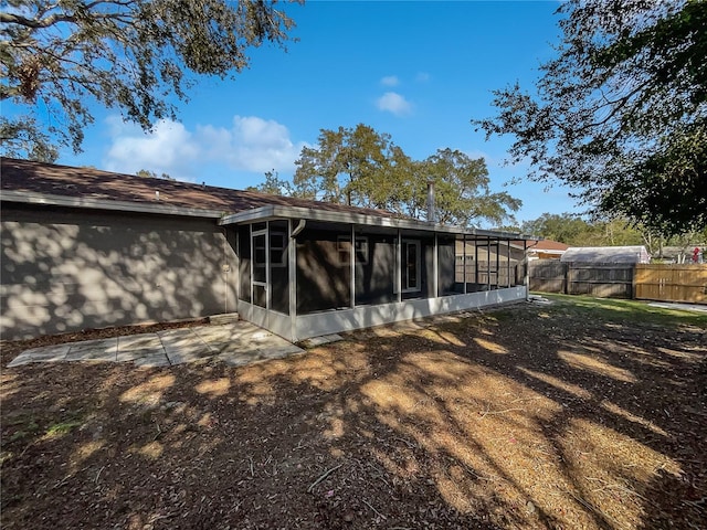 rear view of house featuring a sunroom