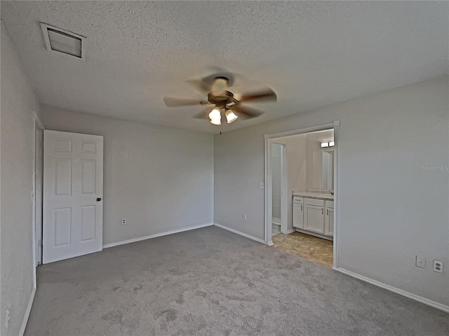 carpeted spare room with a textured ceiling and ceiling fan