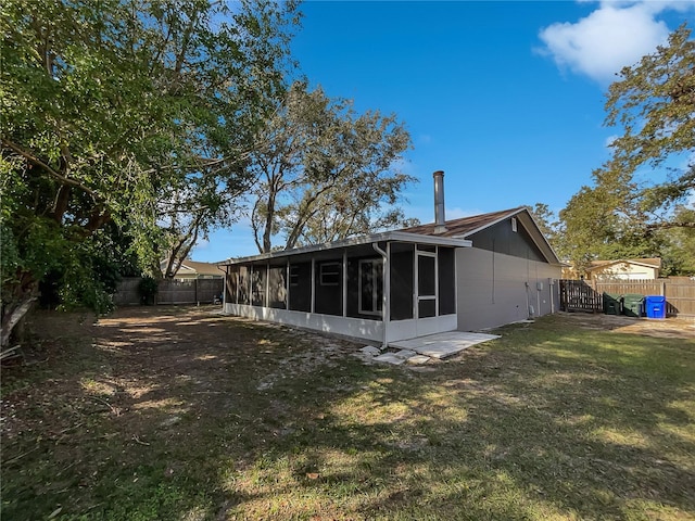 back of house featuring a sunroom and a yard