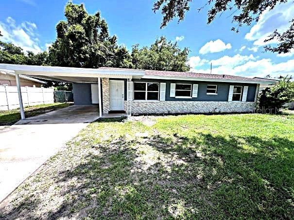 ranch-style house with a carport and a front yard