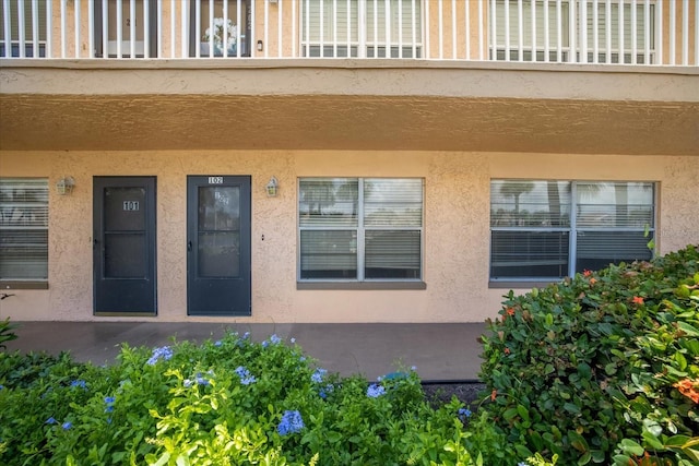 view of exterior entry with a balcony