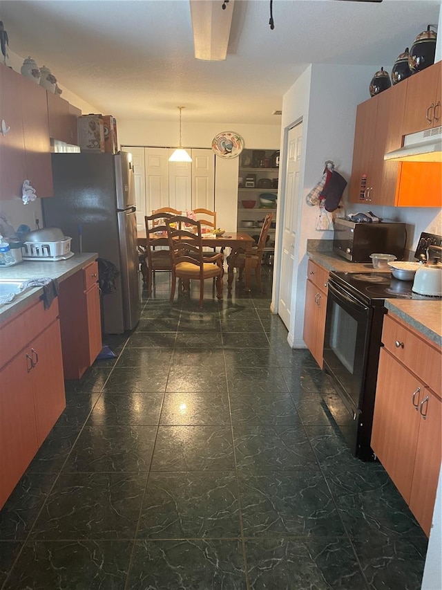 kitchen featuring dark tile patterned floors, stainless steel fridge, hanging light fixtures, and black electric range