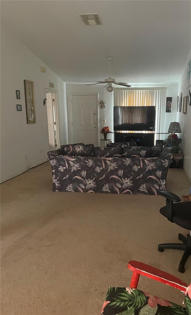 carpeted living room featuring ceiling fan and vaulted ceiling