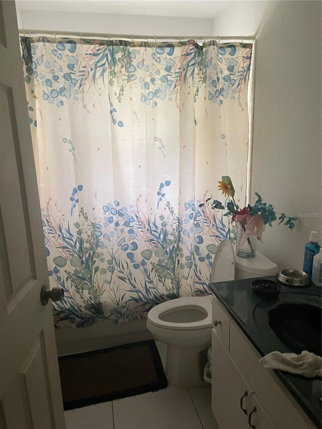 full bathroom featuring toilet, vanity, and tile patterned floors