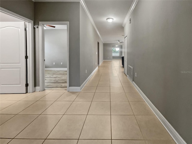 hall featuring light tile patterned floors and ornamental molding