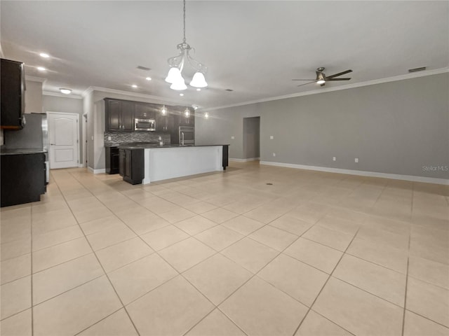 kitchen featuring crown molding, light tile patterned floors, ceiling fan with notable chandelier, a kitchen island, and decorative backsplash