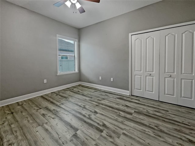 unfurnished bedroom featuring ceiling fan, a closet, and light wood-type flooring