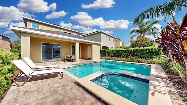 view of swimming pool featuring an in ground hot tub and a patio area