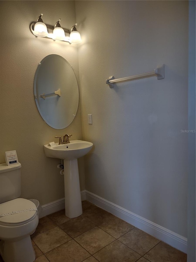 bathroom with toilet and tile patterned floors