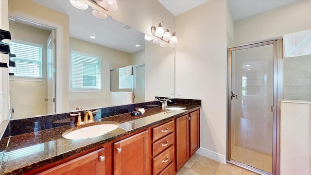 bathroom featuring tile patterned flooring, a shower with shower door, and vanity