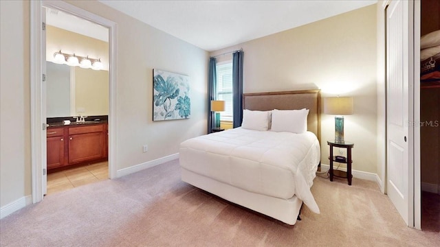 carpeted bedroom with sink and ensuite bathroom