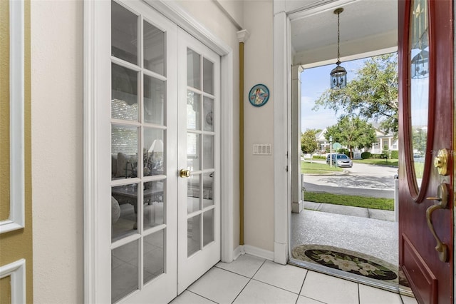 entryway with light tile patterned floors and french doors