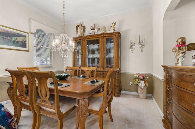 carpeted dining area featuring ornamental molding and a chandelier