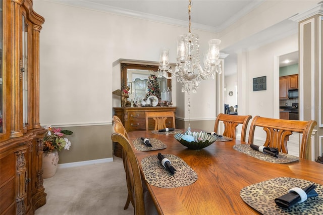 carpeted dining room featuring an inviting chandelier, ornamental molding, and decorative columns