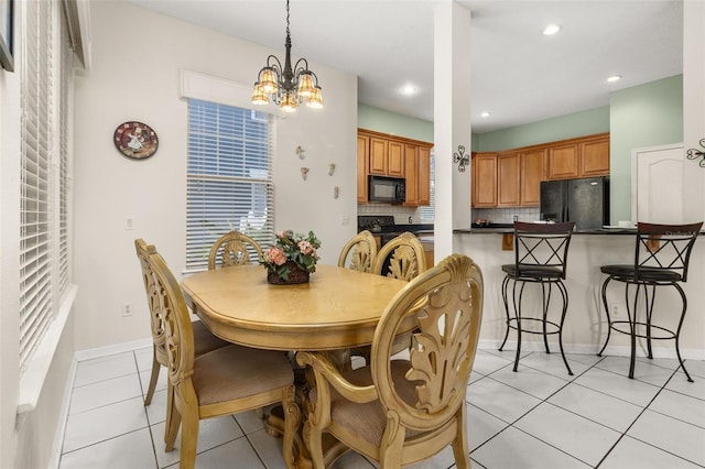 tiled dining room with a notable chandelier