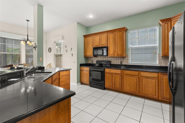 kitchen featuring sink, an inviting chandelier, light tile patterned floors, decorative backsplash, and black appliances