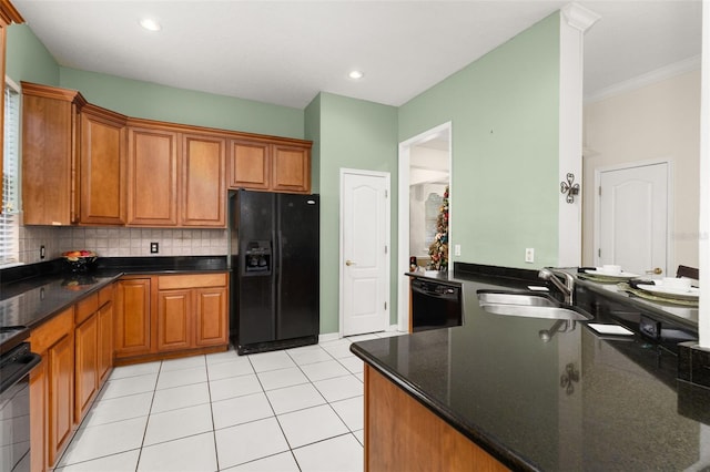 kitchen with light tile patterned flooring, sink, dark stone countertops, decorative backsplash, and black appliances